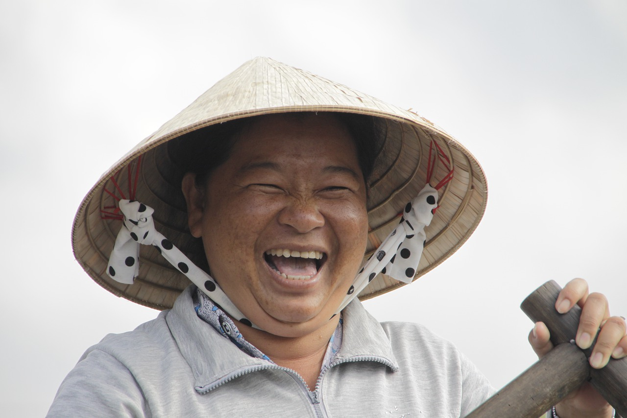 Person laughing while wearing a rice hat